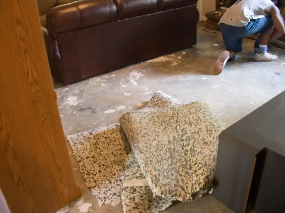 Installer laying hardwood flooring planks in a residential room